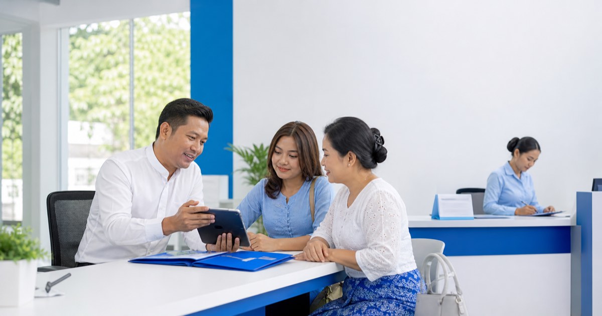 Myanmar admissions coordinator guiding a prospective learner and family member through enrollment